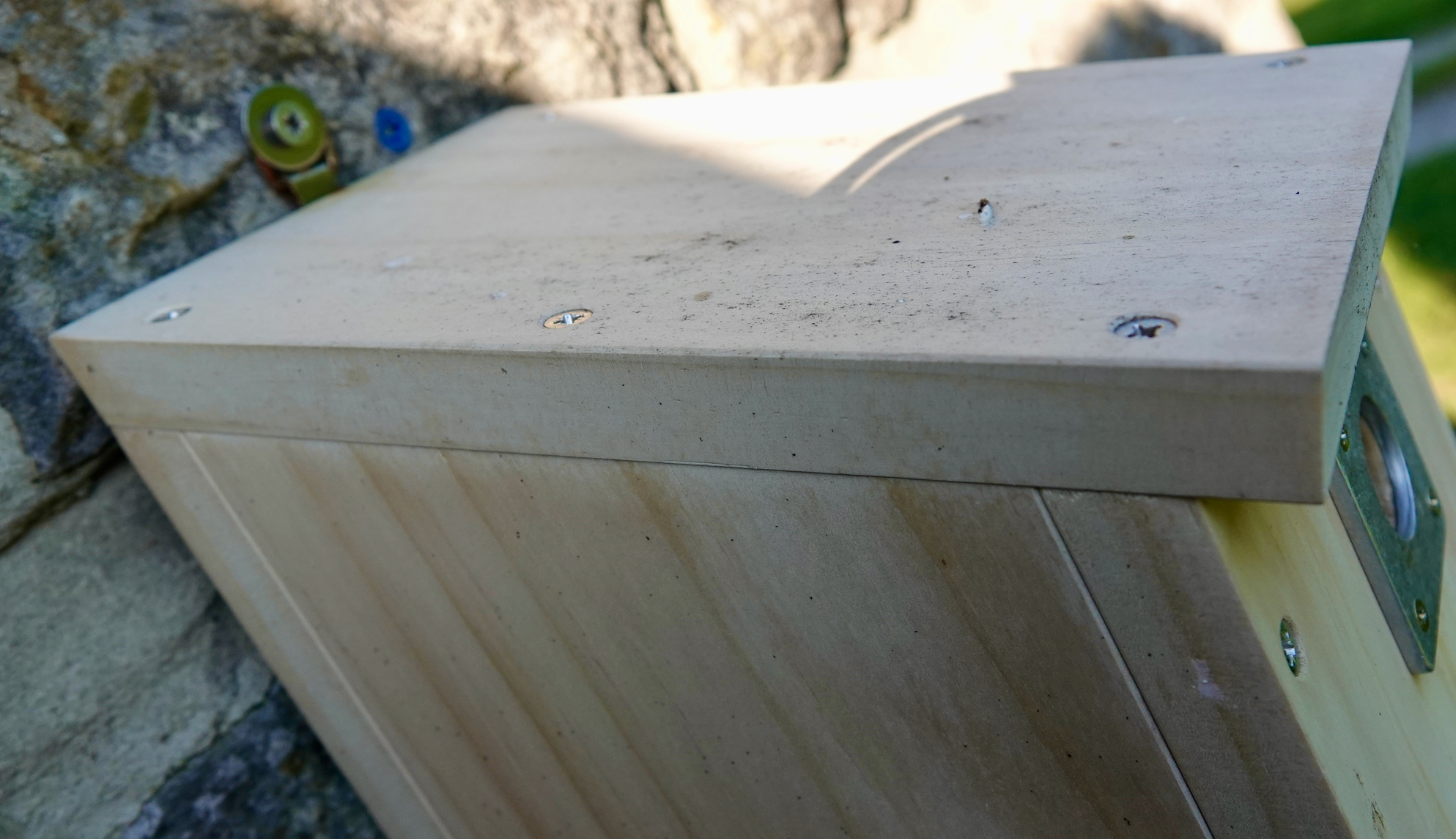 Mounted nest box with green arrows showing the correct positions for the roof screws