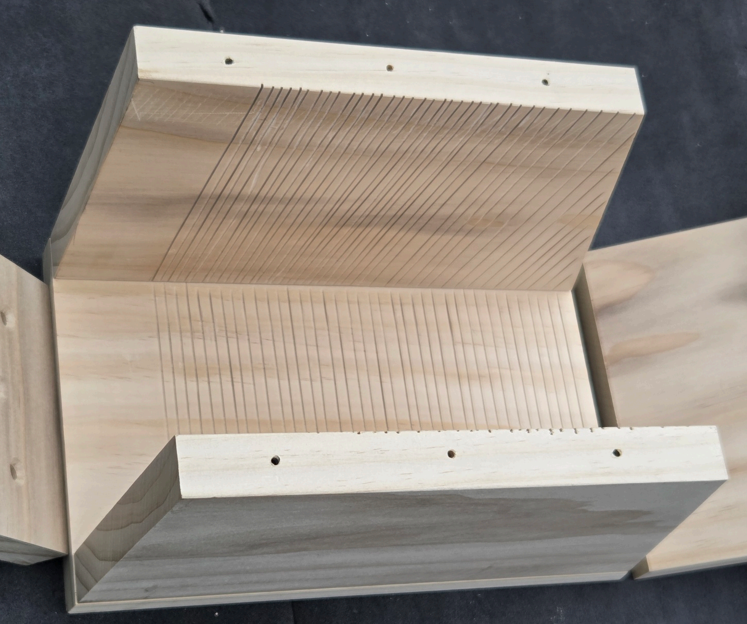 Nest box floor piece with several drainage holes drilled into it